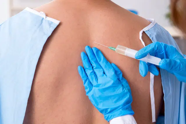 Doctor makes a Connective tissue injection to the patients back due to cell damaged